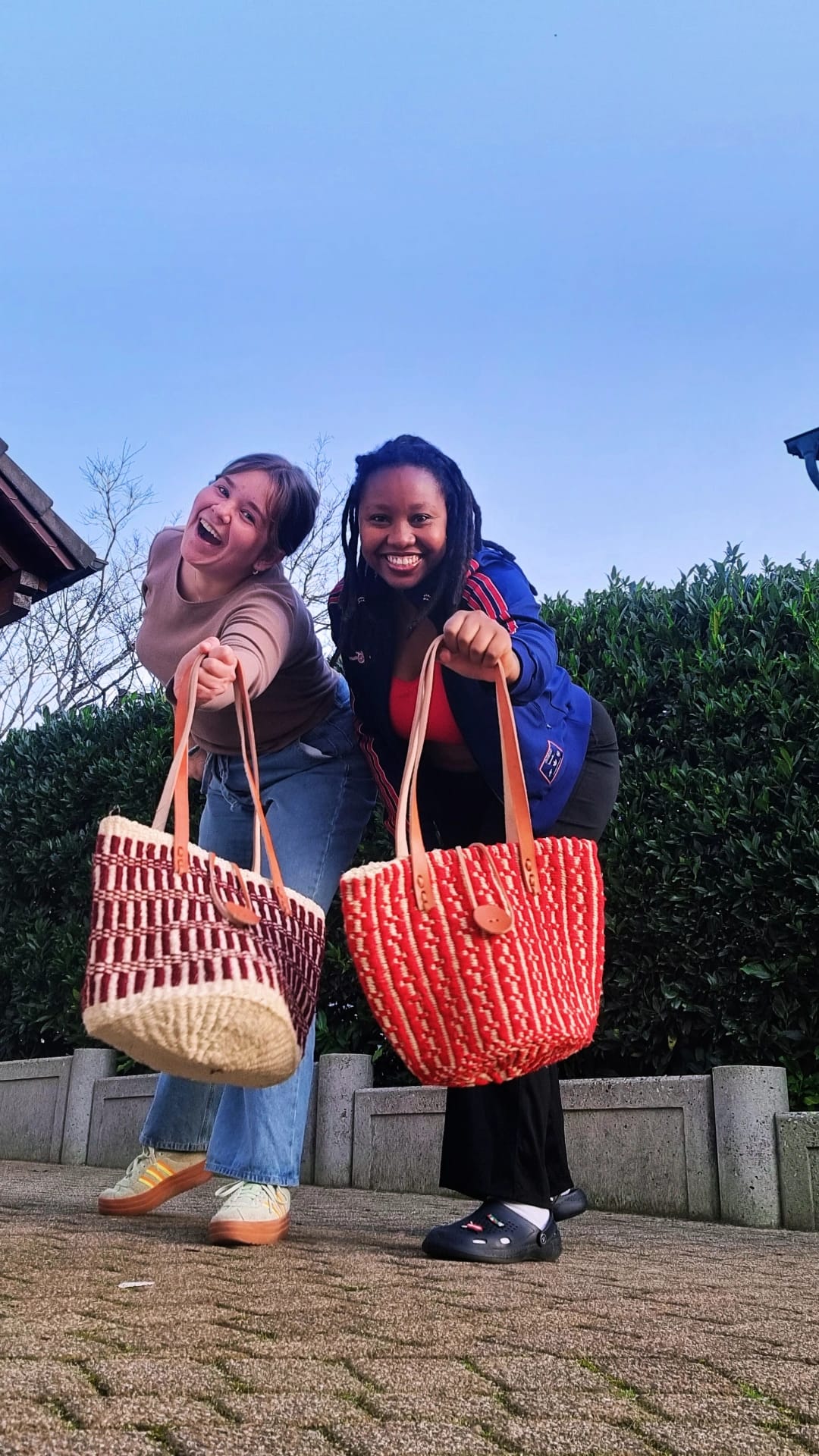 Customers holding woven basket bags outdoors