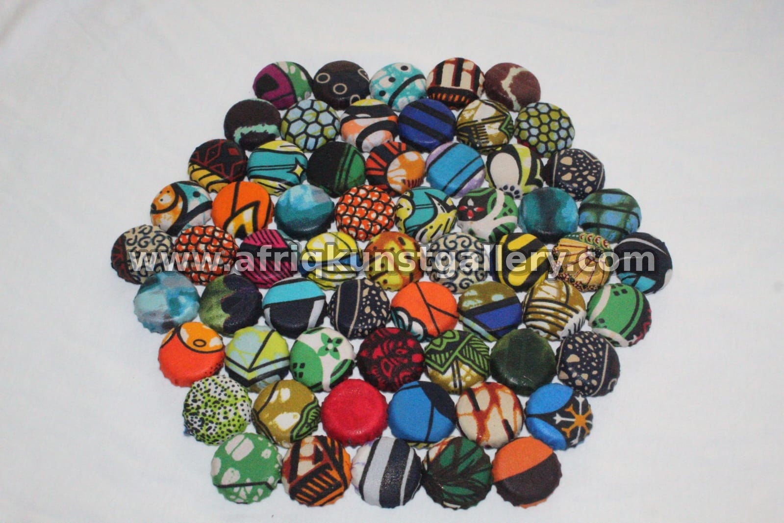 Assorted colorful painted bottle top art pieces with vibrant hand-painted designs.