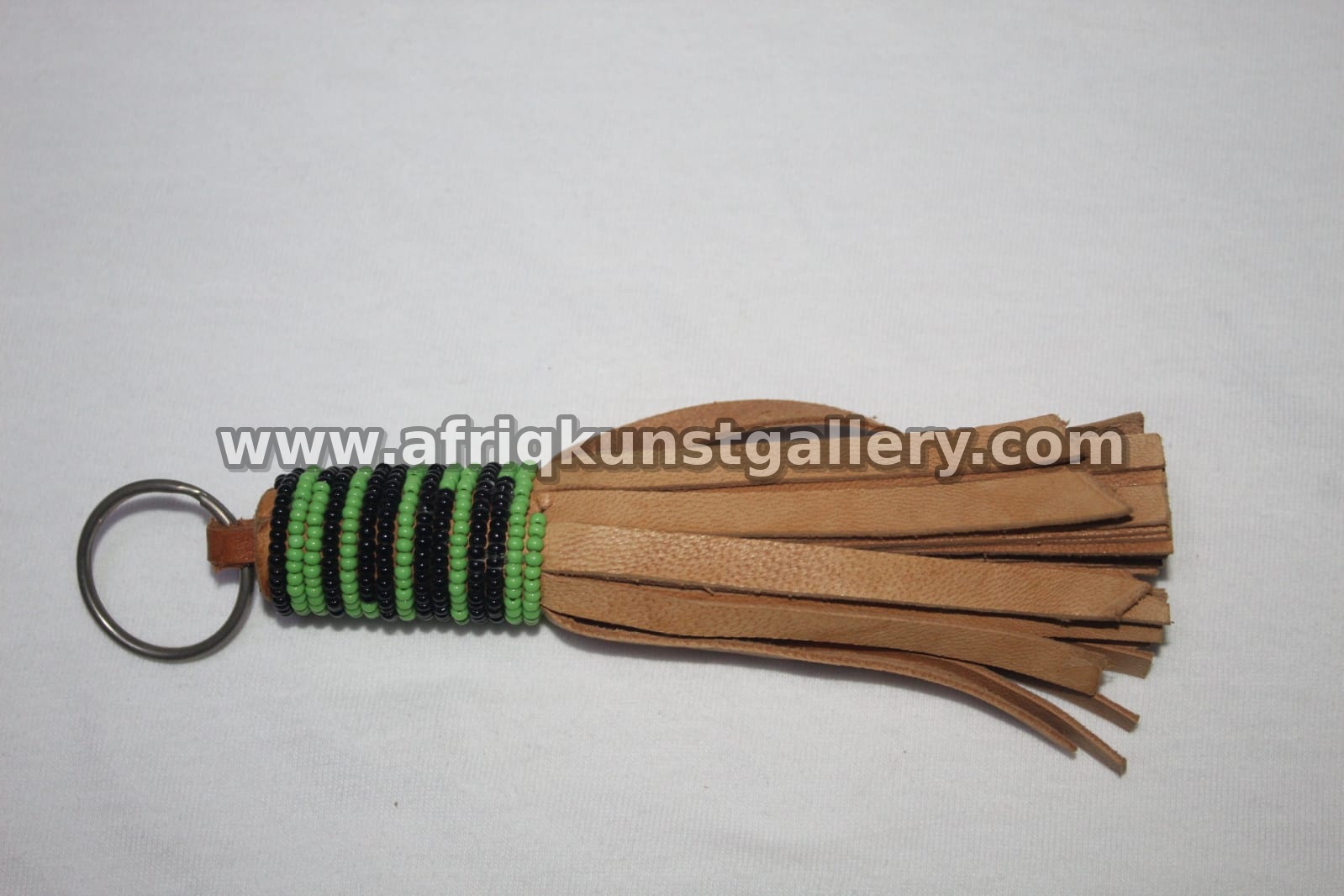 Leather tassel keyholder with green and yellow bead wrap.