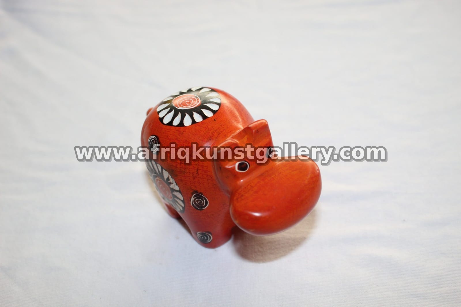 Small orange soapstone rhino sculpture.