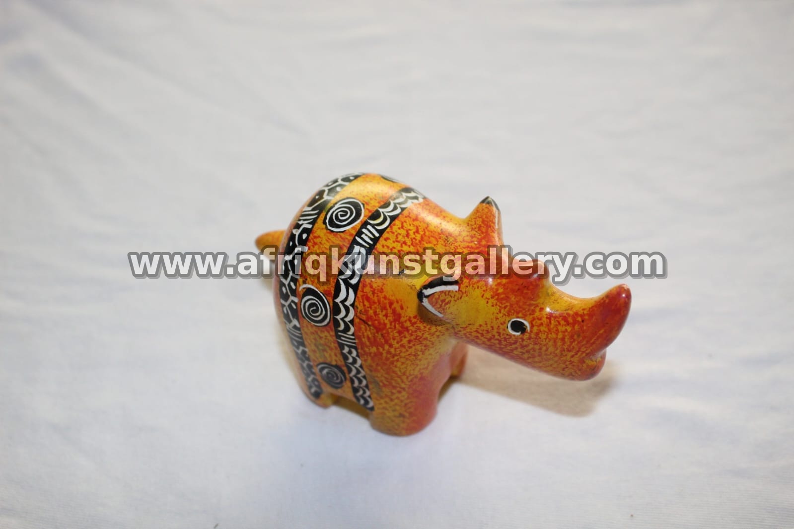 Orange soapstone rhino sculpture with black and yellow painted accents.