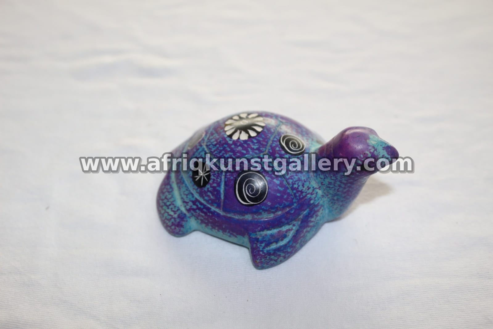 Purple soapstone hippo sculpture with painted accents.
