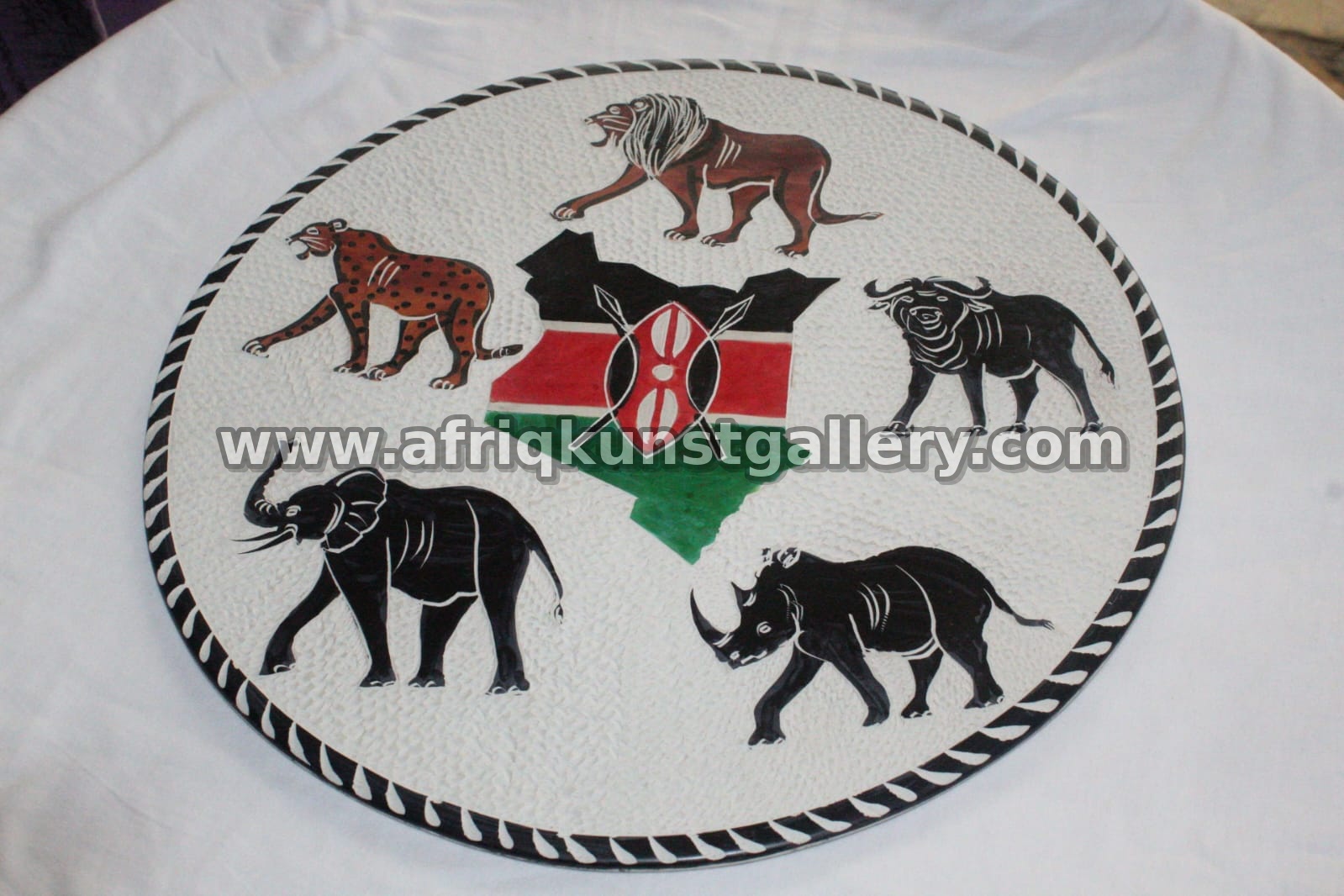 Round serving plate painted with African wildlife silhouettes.