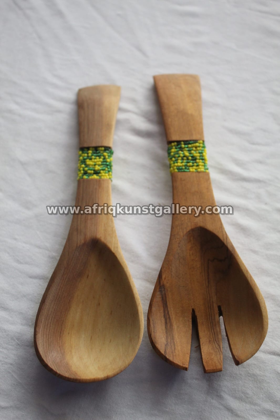 Pair of wooden serving utensils with beaded handles.