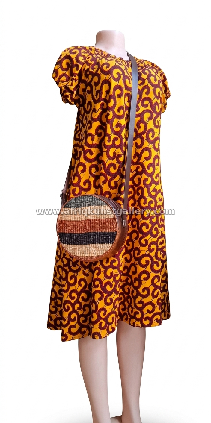 Orange patterned midi dress styled with a round woven crossbody bag.